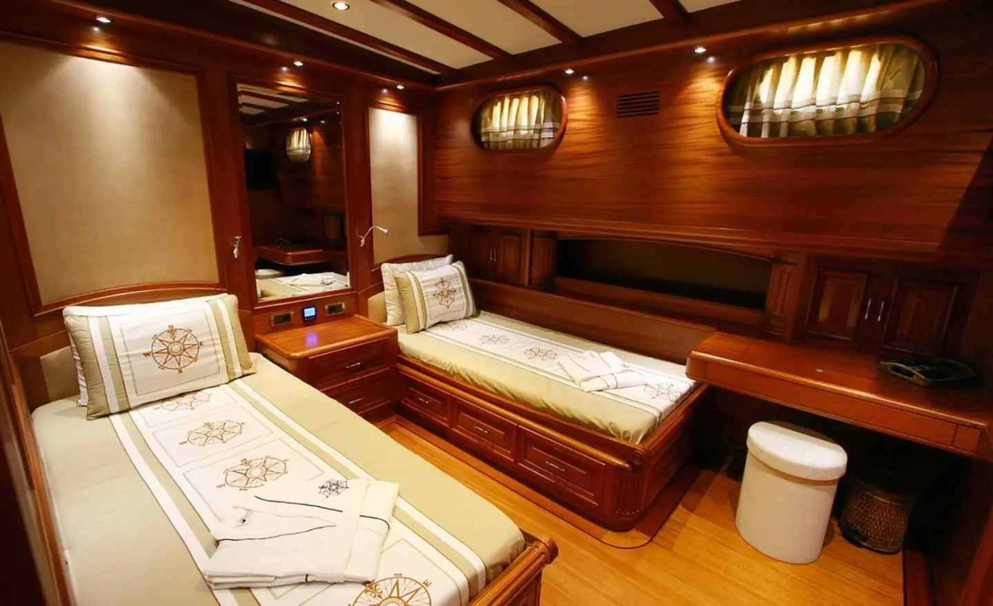 Interior of Kaya Guneri 5 gulet with three single beds, wood paneling, and warm lighting