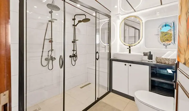 Bathroom aboard Esma Sultan yacht: shower stalls, glass doors, and sink visible