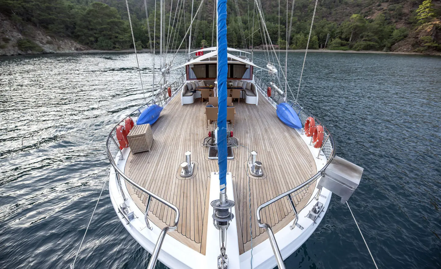Top-down view of Kayhan 5 yacht moored at sunset with wooden deck and blue cushions