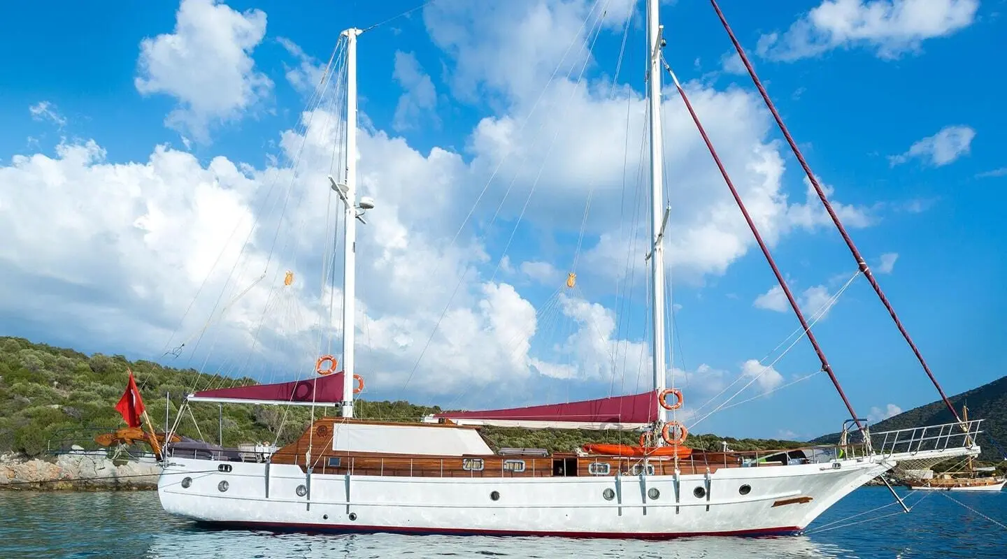 Primadonna luxury gulet anchored at sea with clear blue sky and sails
