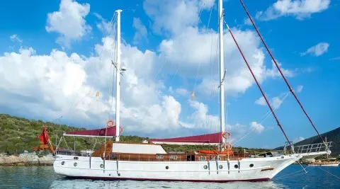 Primadonna luxury gulet anchored at sea with clear blue sky and sails