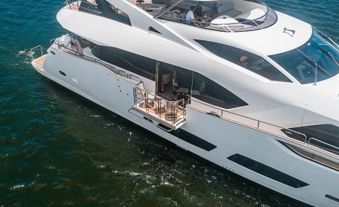 Sunset view of the luxury yacht Quantum's side deck with seating area and stairs on the open sea