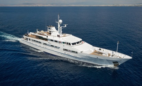 White motor yacht sailing on open sea with deck lounge area