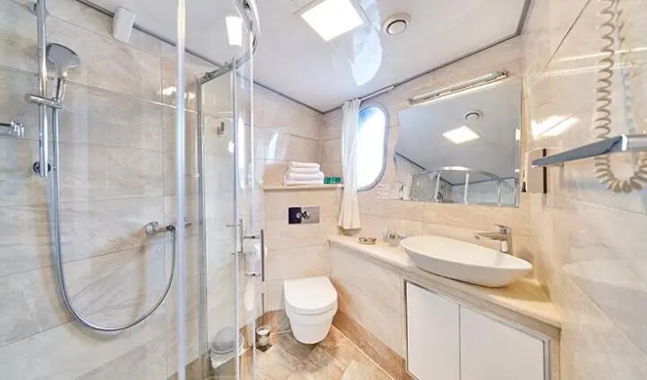 Casablanca yacht cabin interior with glass shower, modern sink, and compact toilet