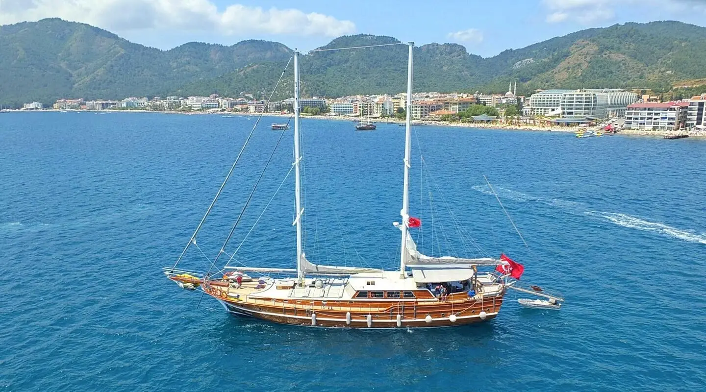 Kaptan Mehmet Bugra gulet anchored in calm blue harbor with mountains