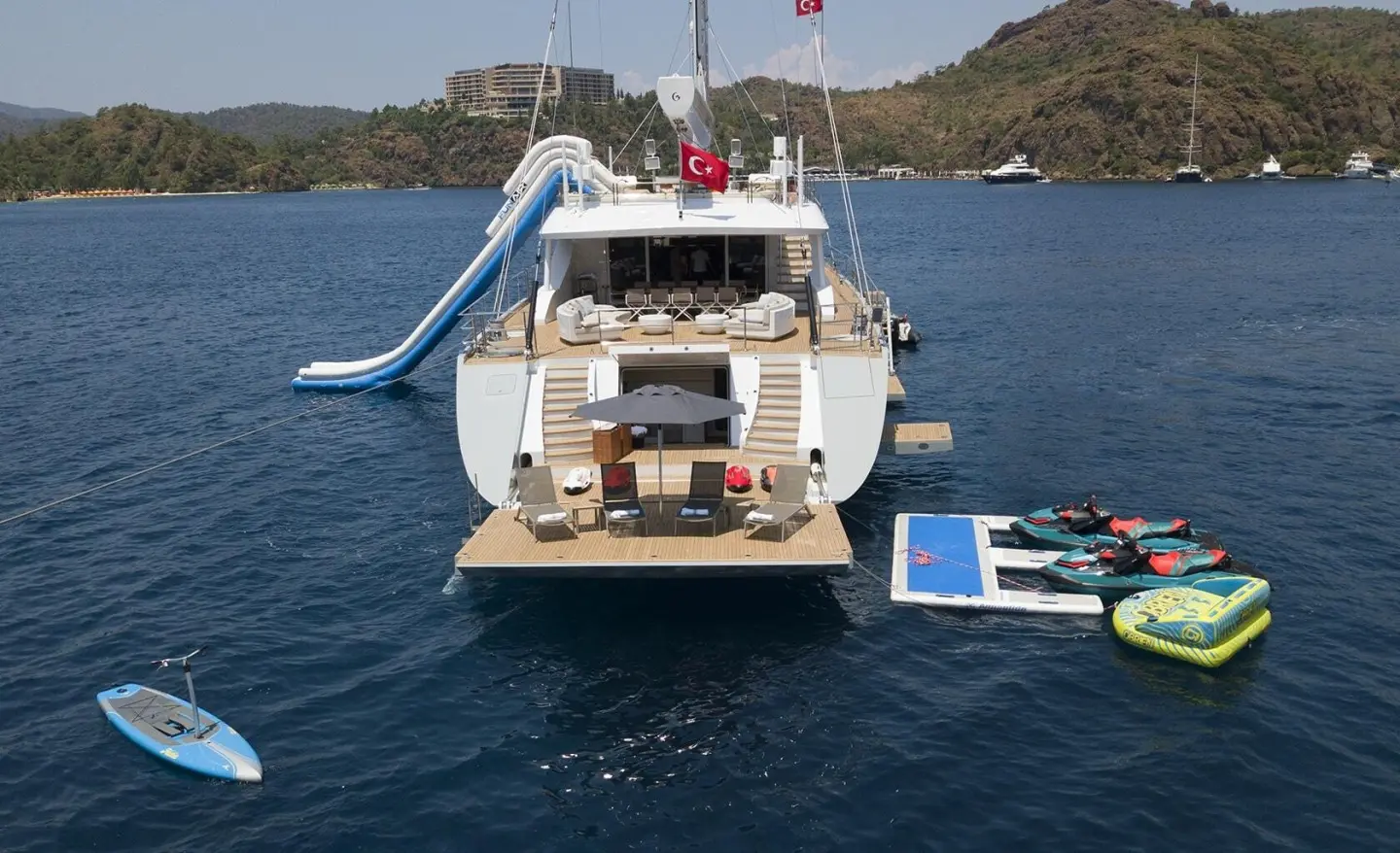All About U 2 luxury yacht anchored with aft deck sun loungers and water slide on blue sea