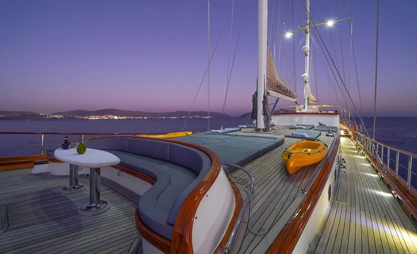 La Bella Vita yacht deck at dusk with polished wood, seating, and rigging