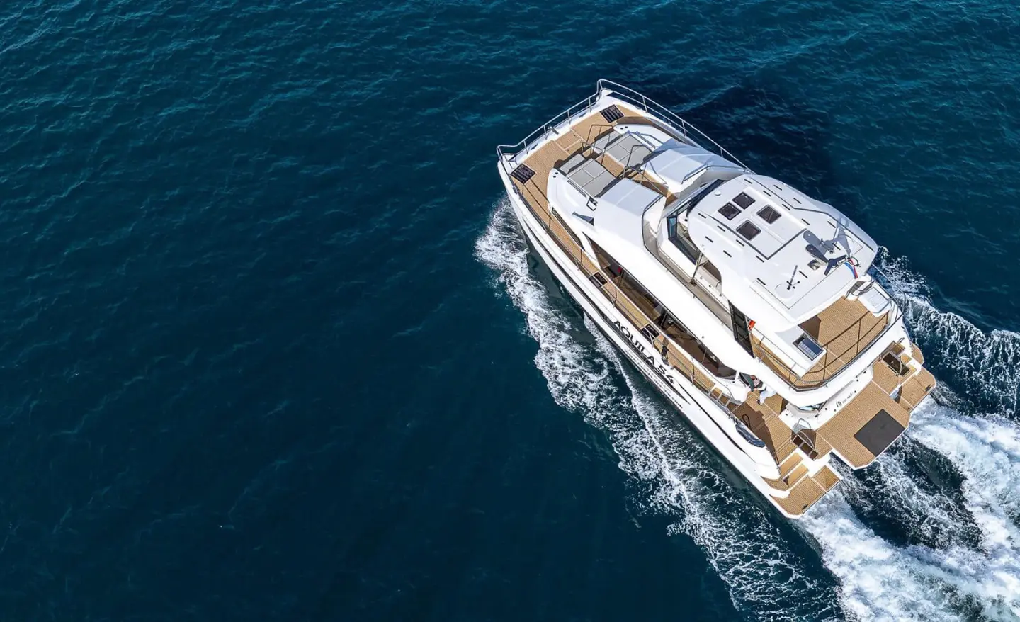 Overhead view of a luxury yacht named By My Side sailing on calm blue water at sunset