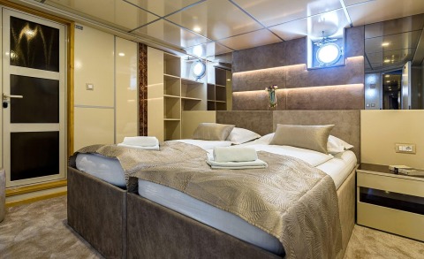 Melody luxury yacht cabin interior with twin beds, plush beige bedding, and soft ambient lighting