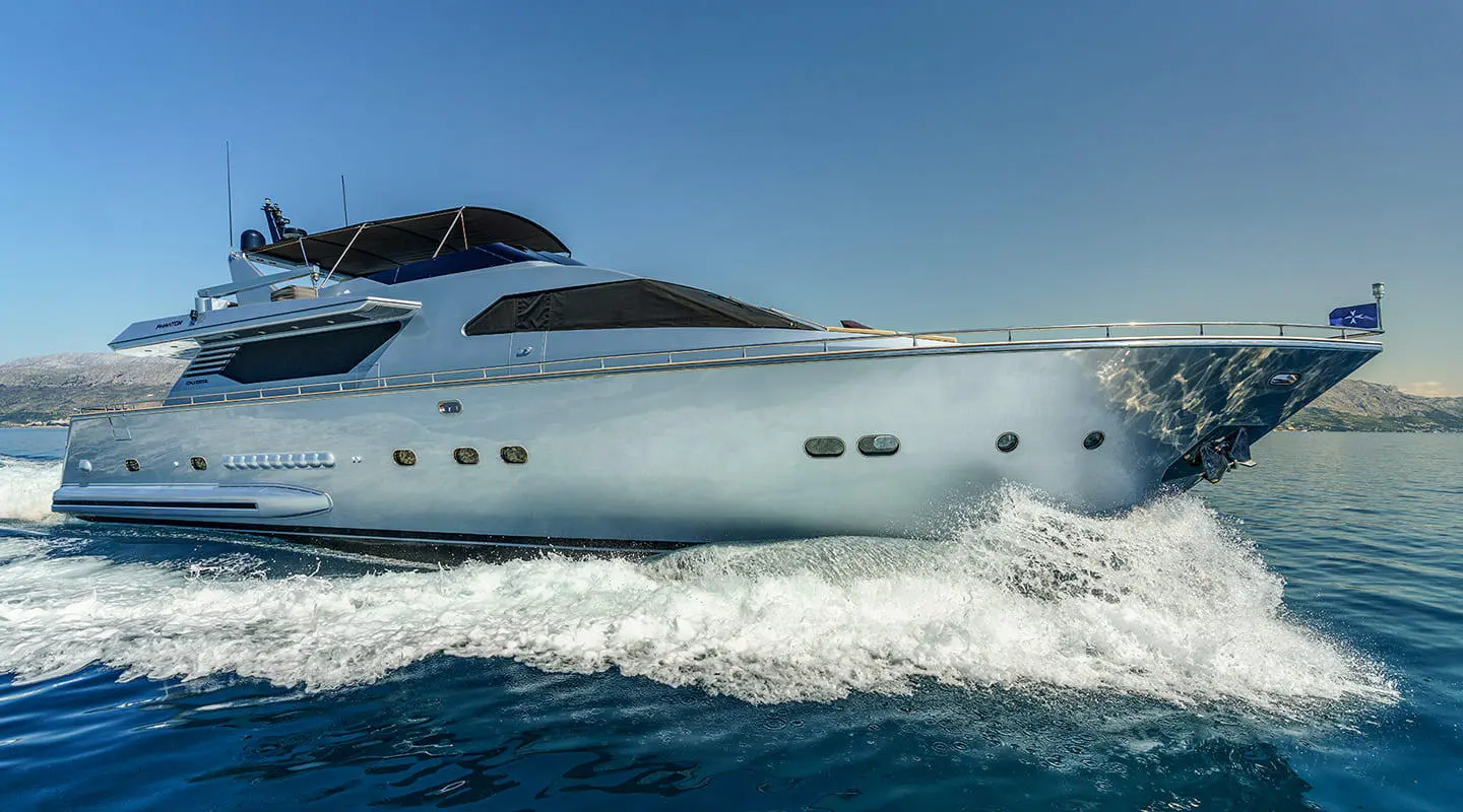 Phantom motor yacht cruising on blue sea with waves, side view