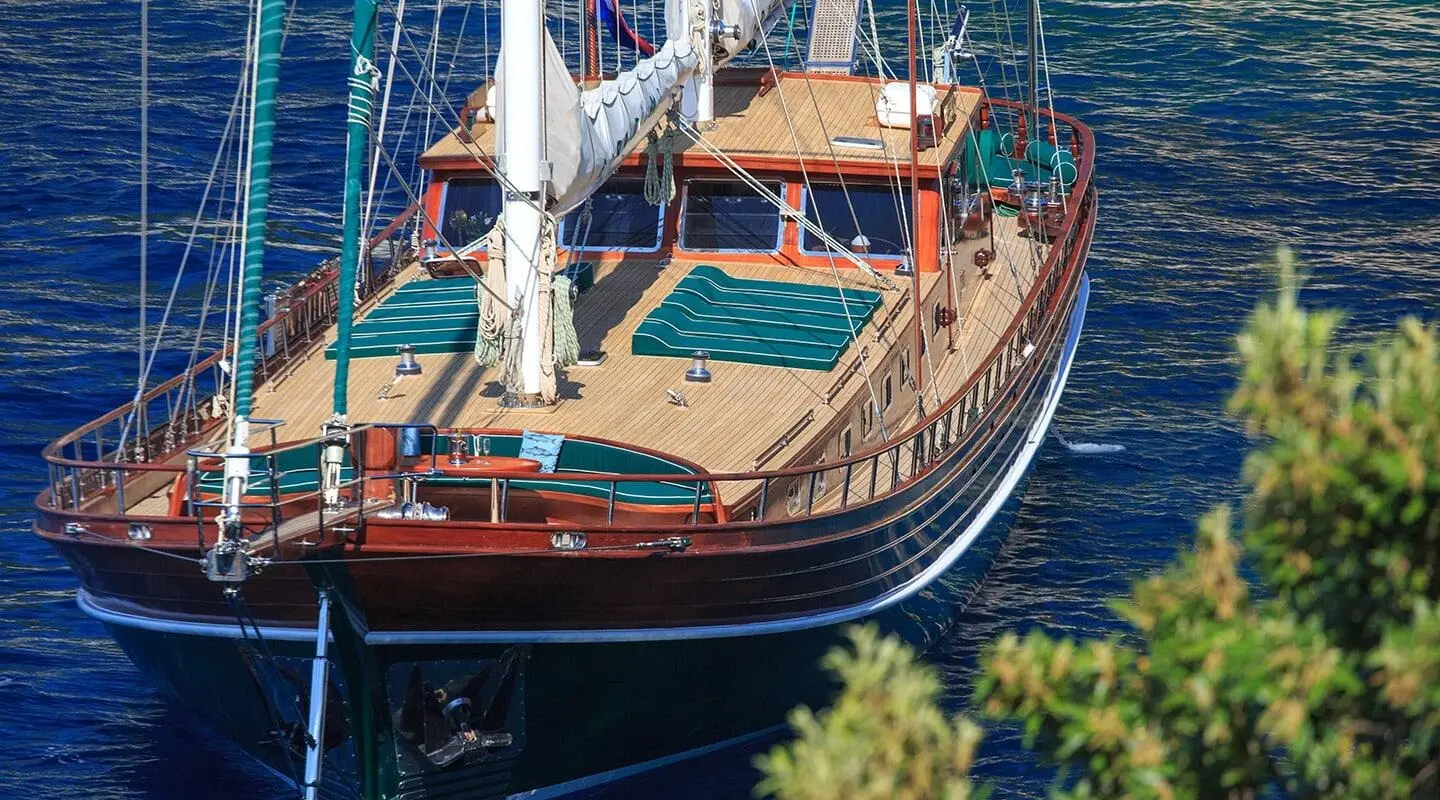 Carpe Diem 7 yacht at sea with wooden deck and sails at sunset