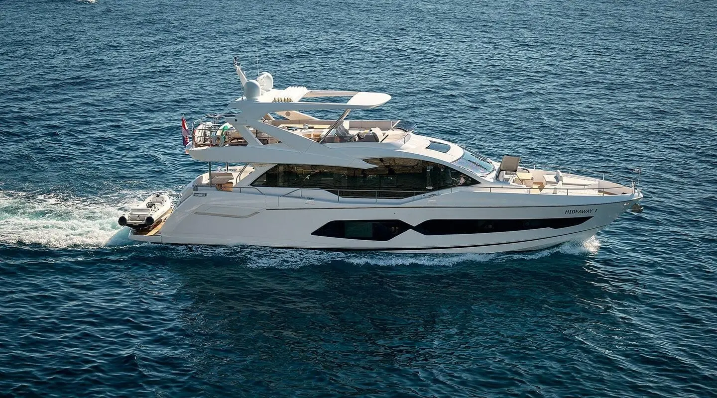 White luxury motor yacht on blue water, visible windows and deck area