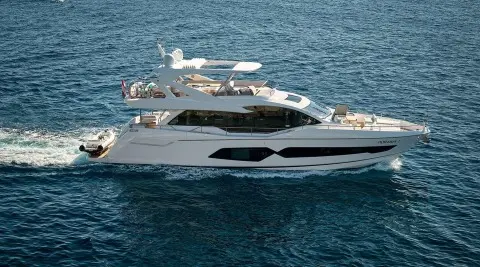 White luxury motor yacht on blue water, visible windows and deck area