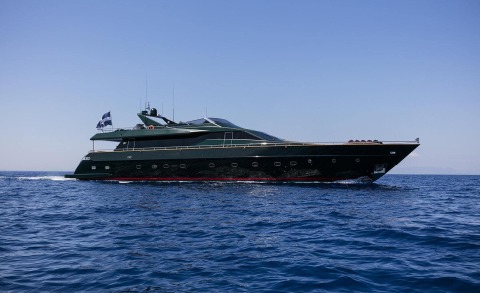 Dark green luxury motor yacht cruising blue seas, sleek profile, sun deck and windows along hull