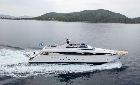 Pareaki II yacht sailing on calm water with distant hilly coastline