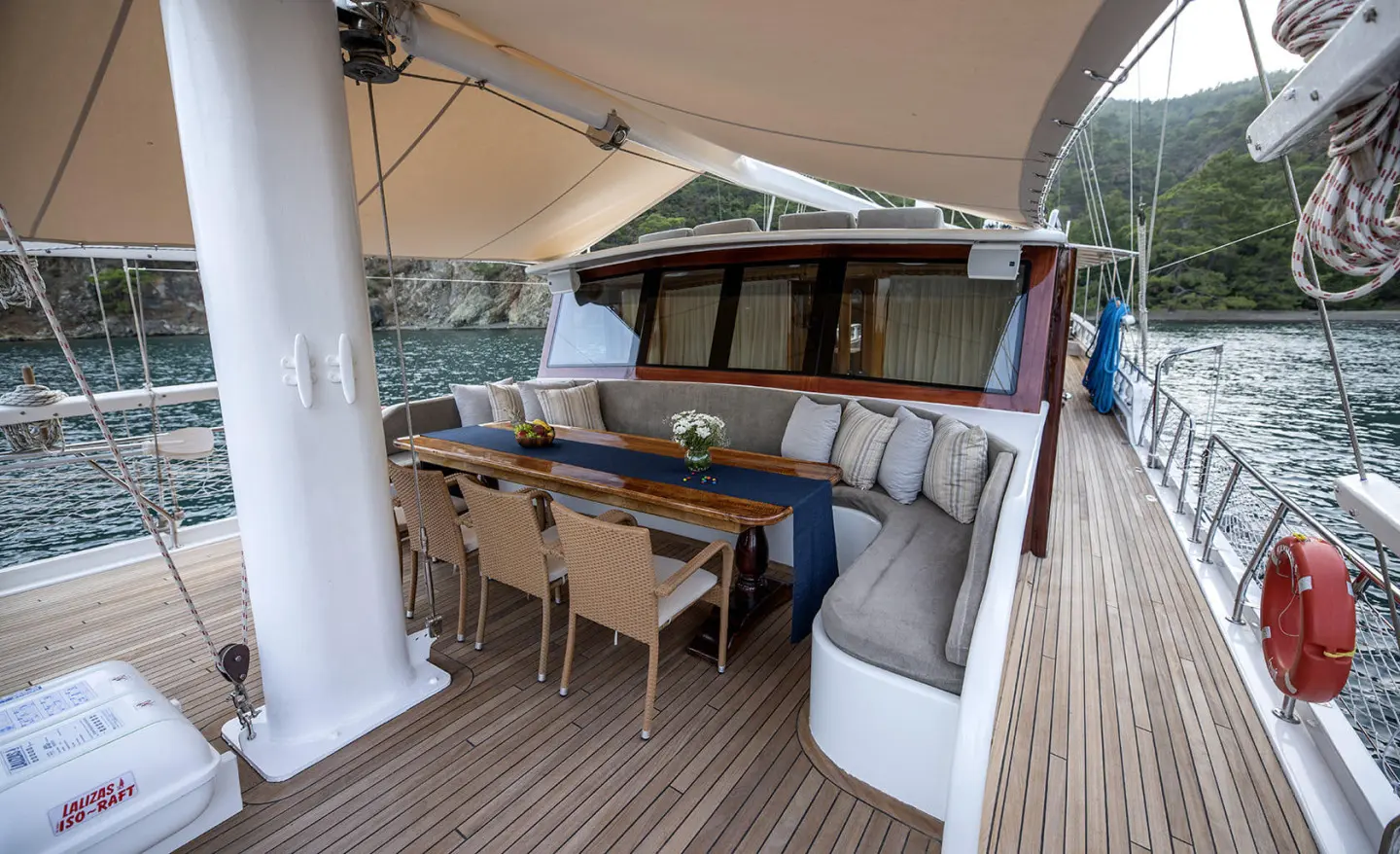 Kayhan 5 gulet lounge area with wooden deck, seating, and shaded canopy