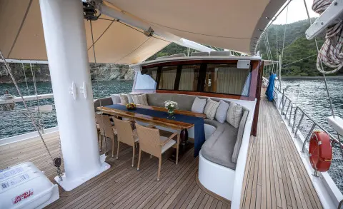 Kayhan 5 gulet lounge area with wooden deck, seating, and shaded canopy