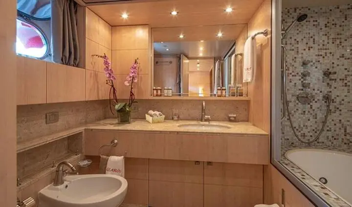 Glaros yacht master cabin with king bed, ensuite layout, warm wood tones