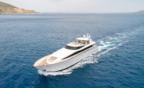 Aquila yacht, white superstructure with dark windows and open sun deck with seating, cruising on blue sea
