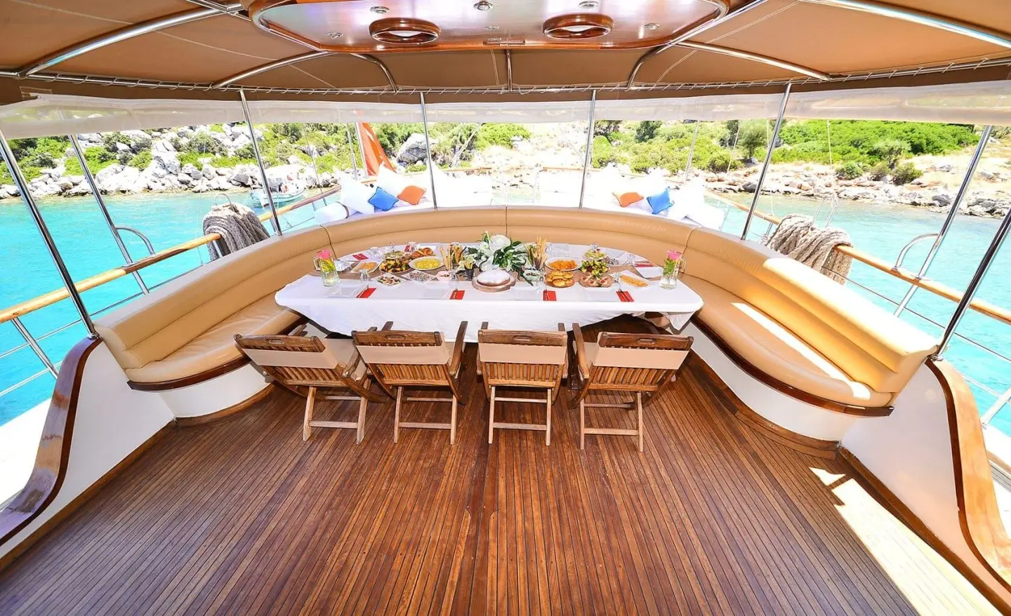 Deck seating on a luxury gulet with curved benches and table under an awning