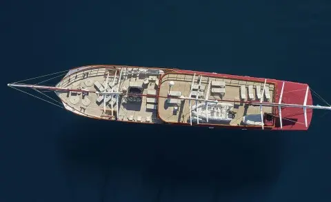Aerial view of a white motor yacht Amorena docked in deep blue sea, deck visible