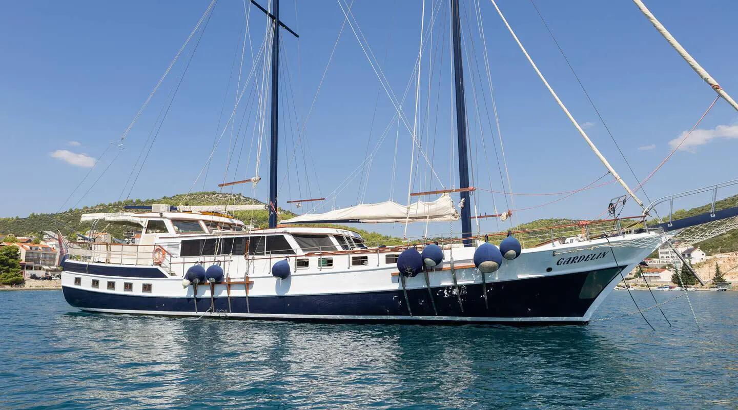 Gardelin luxury gulet yacht docked at sunset with sails and calm water