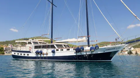 Gardelin luxury gulet yacht docked at sunset with sails and calm water