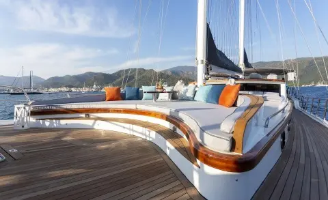 Luxury gulet Diva Deniz on deck with curved seating and colorful cushions