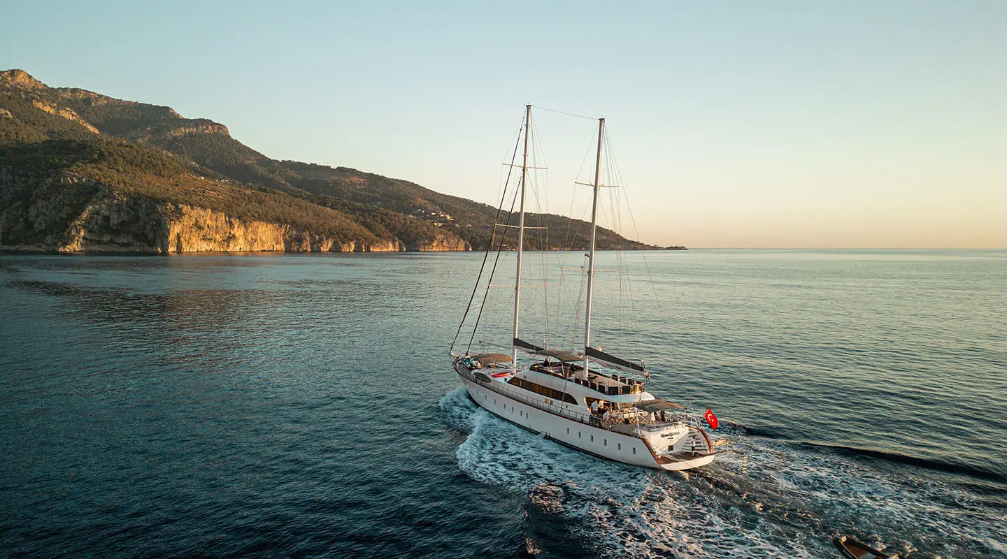 Gulet Queen Of Makri sailing near coastline with calm blue sea