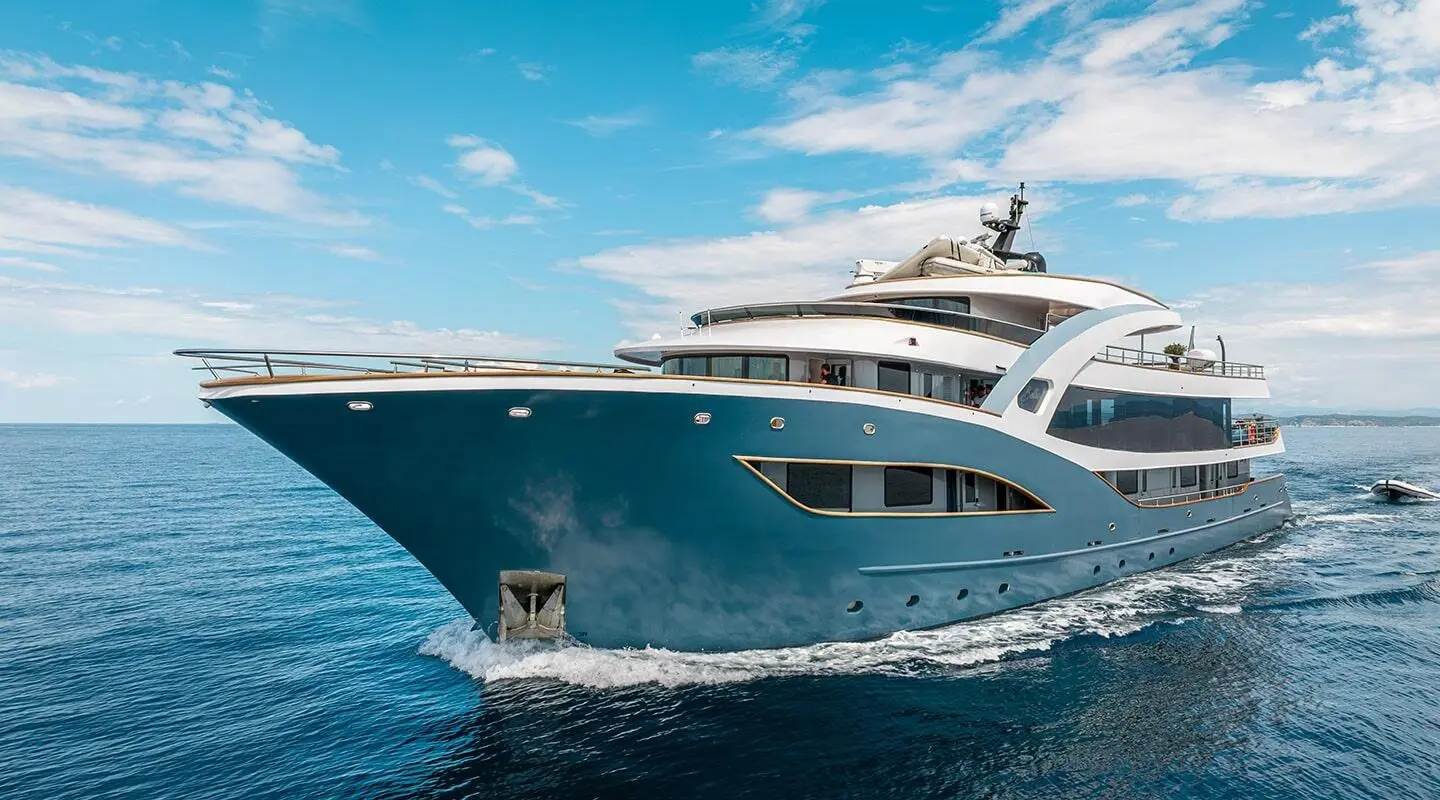Blue motor yacht Bella seen from the bow with upper decks visible at sea
