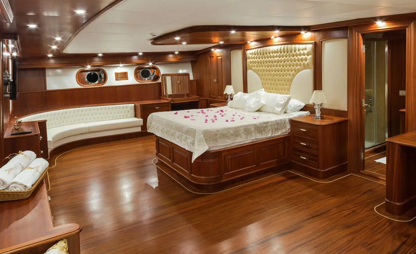 Gulet Halcon Del Mar master cabin with bed, wood floors, and porthole windows