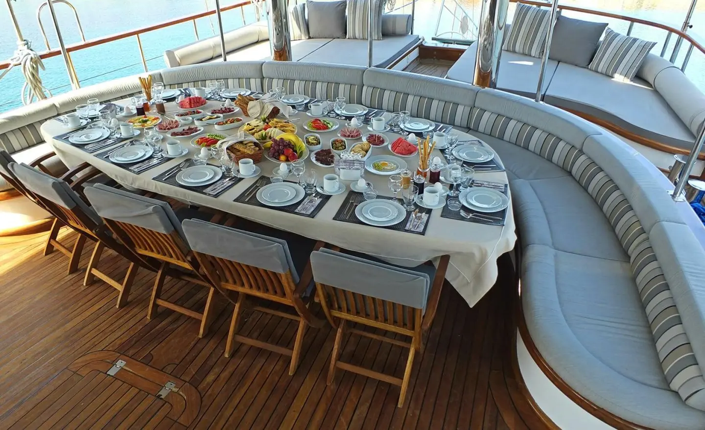 Kaptan Mehmet Bugra yacht dining table set for guests on deck with plates
