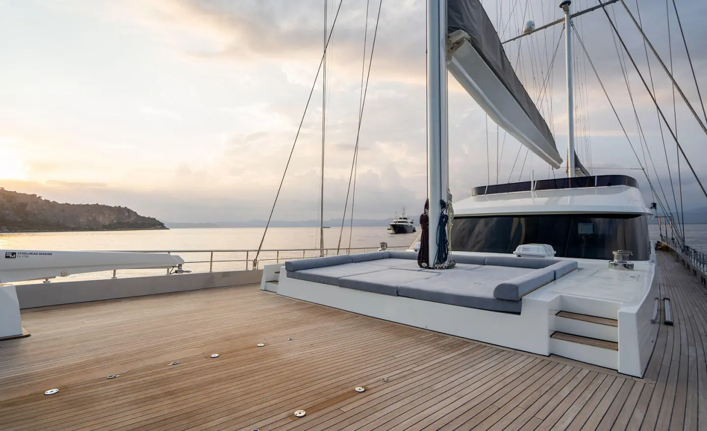 De Love yacht deck at sunset with sails raised and calm water