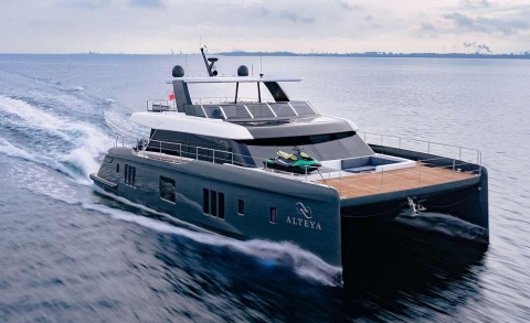 Alteya motor yacht cruising at sea, forward view with glass enclosed bridge and teak deck lounge area