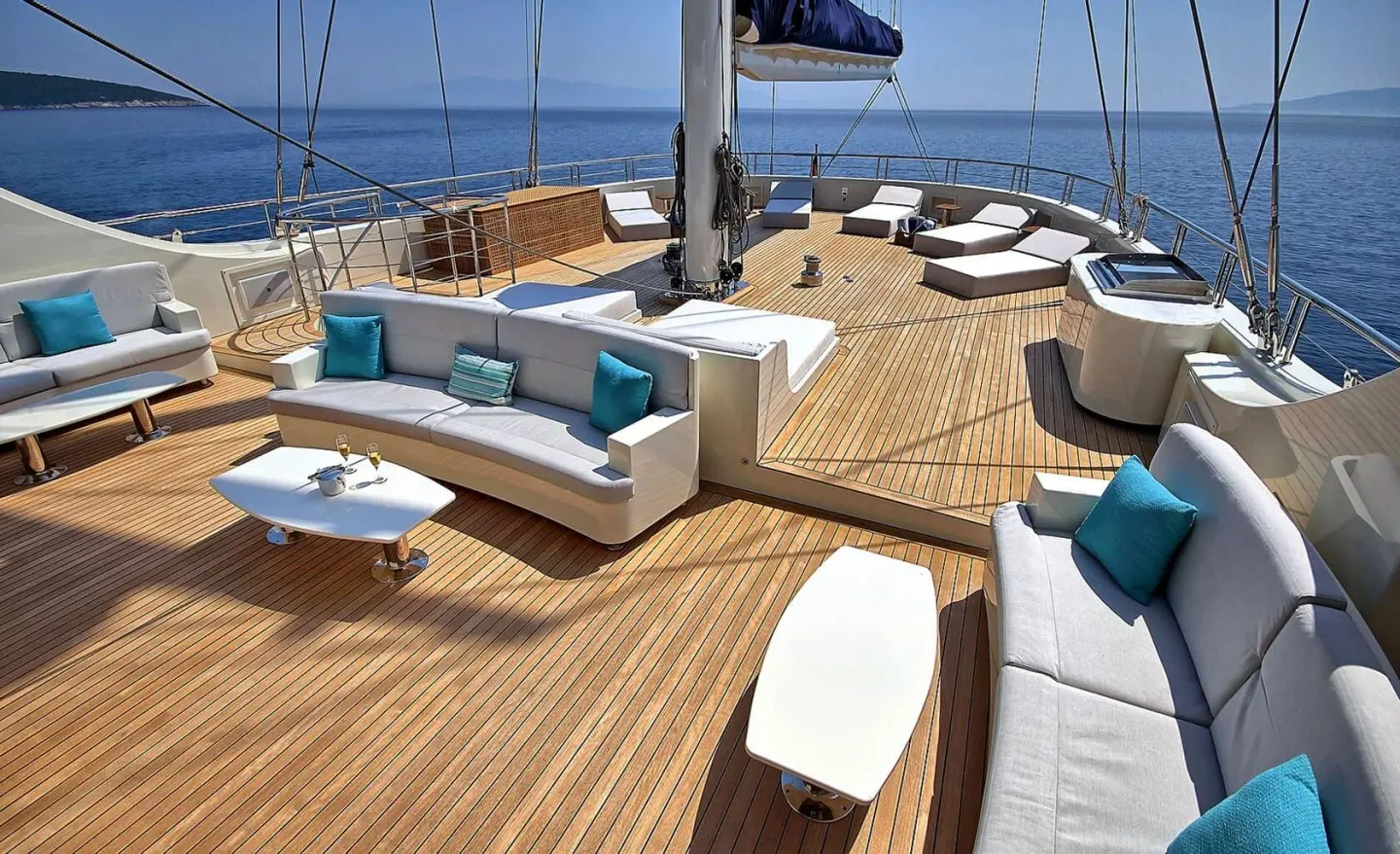 Meira yacht deck with sun loungers, seating area, and blue sea backdrop