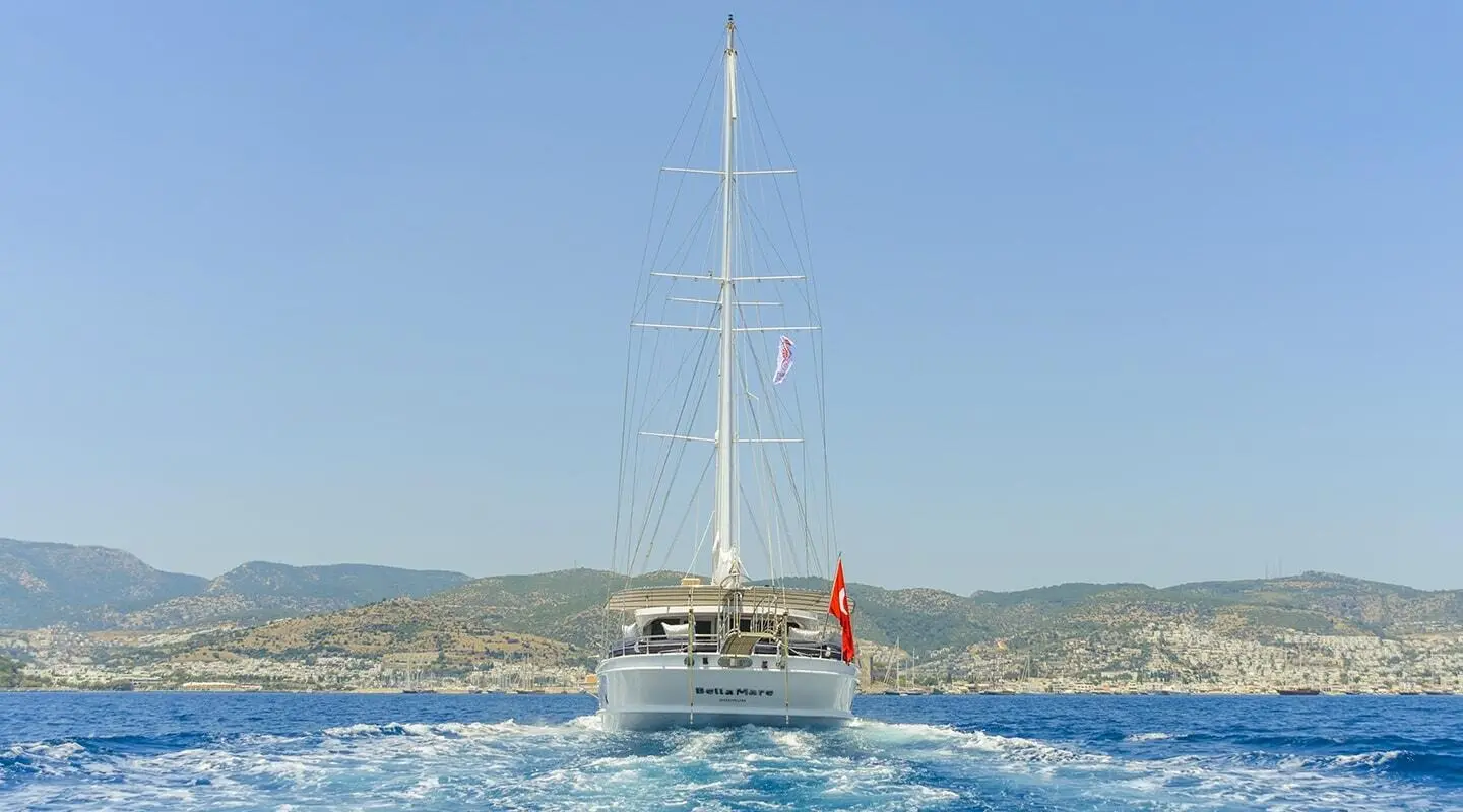 Bella Mare yacht sailing on calm blue sea at sunset with clear sky