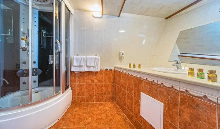 Luna cabin ensuite bathroom: wooden vanity, tiled floor, mirror, and sink