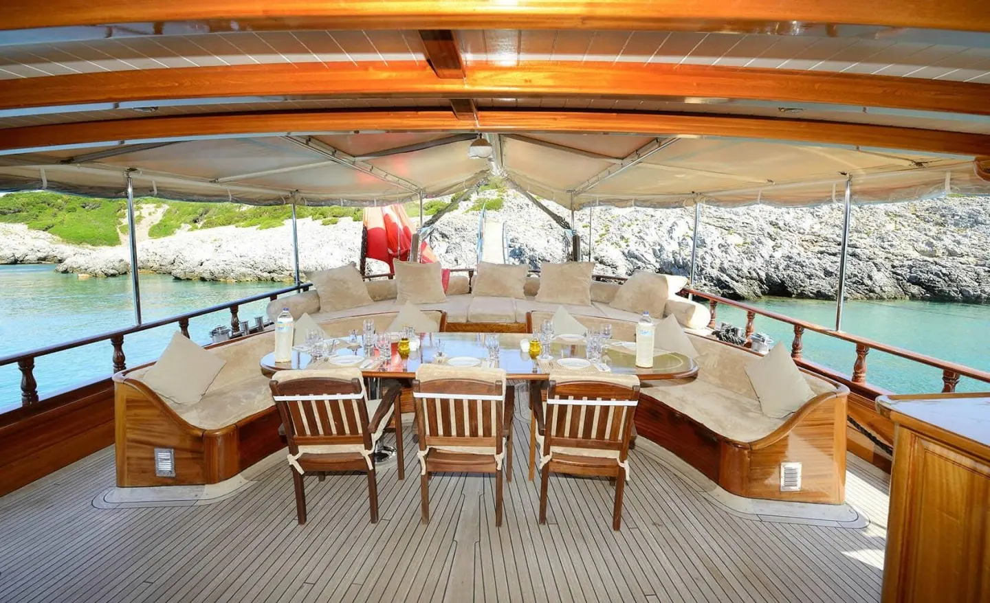 Luxurious yacht deck with a dining table and beige cushions