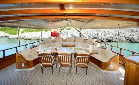 Luxurious yacht deck with a dining table and beige cushions