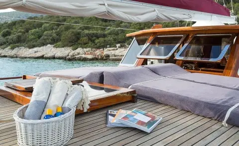 Primadonna gulet sun deck with cushioned seating and wicker basket