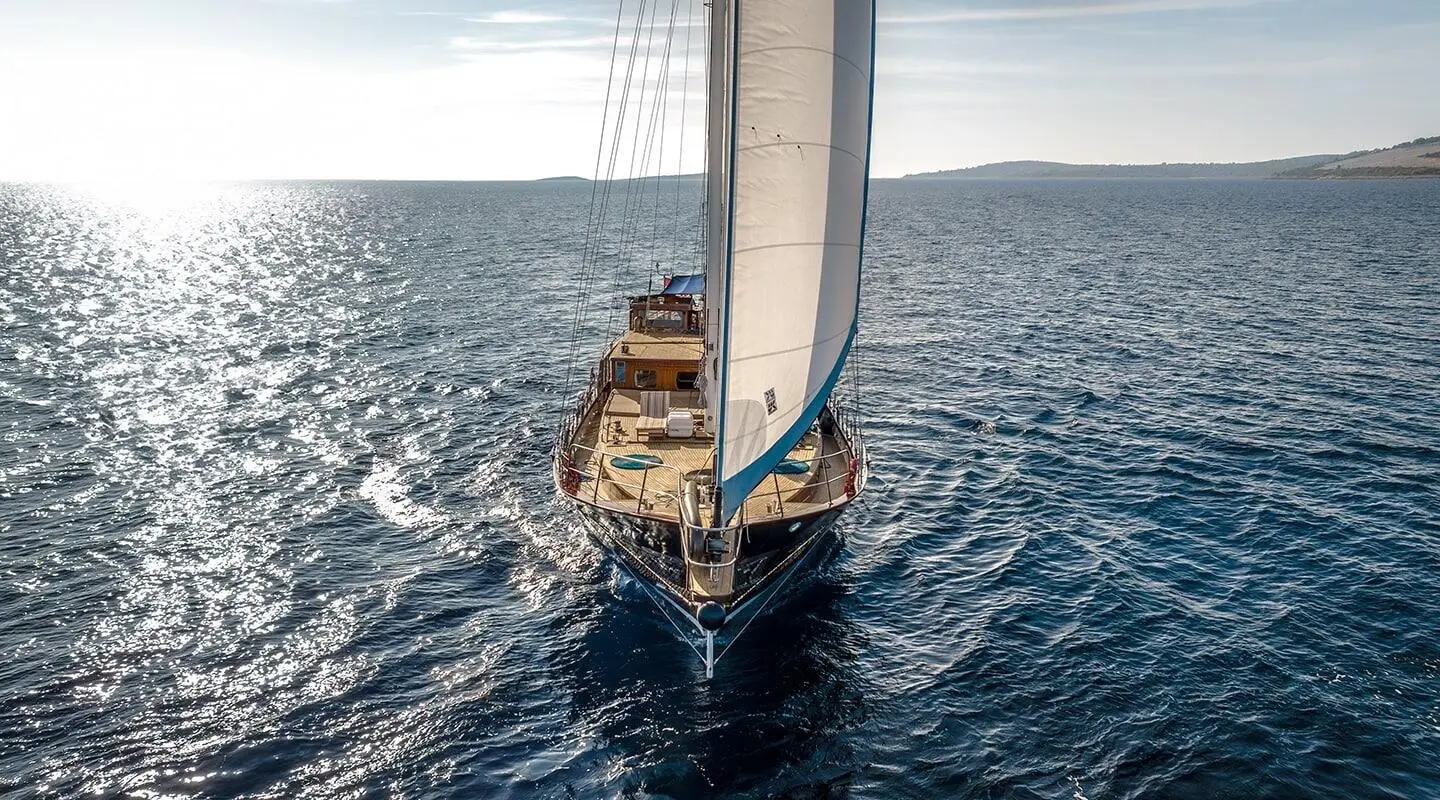 Top-down view of the Smart Spirit sailing yacht with white sails on blue sea