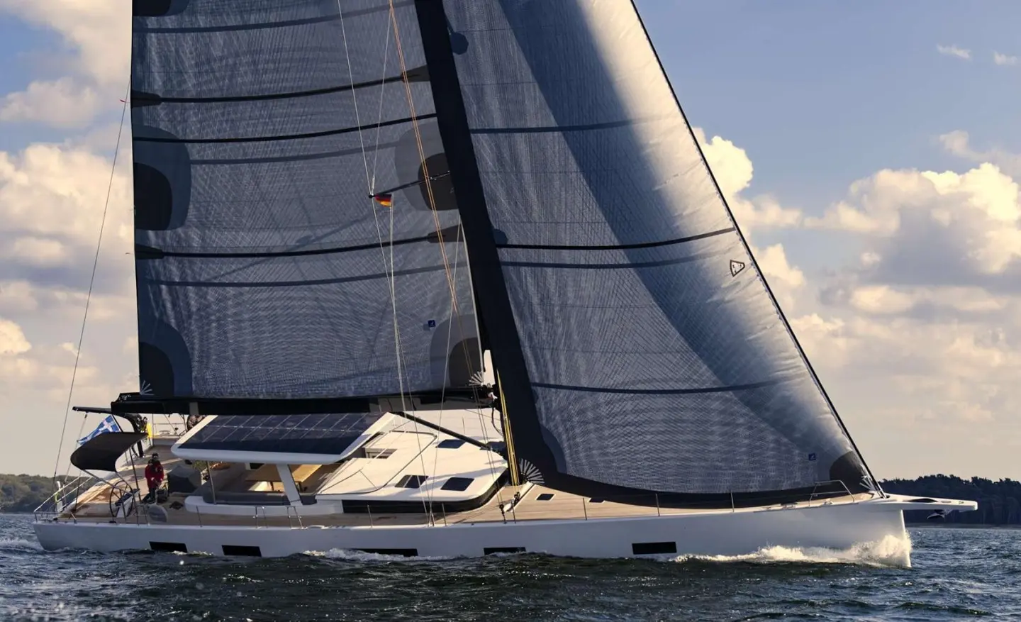 Nadamas yacht sails on blue sea with tall dark sails catching wind