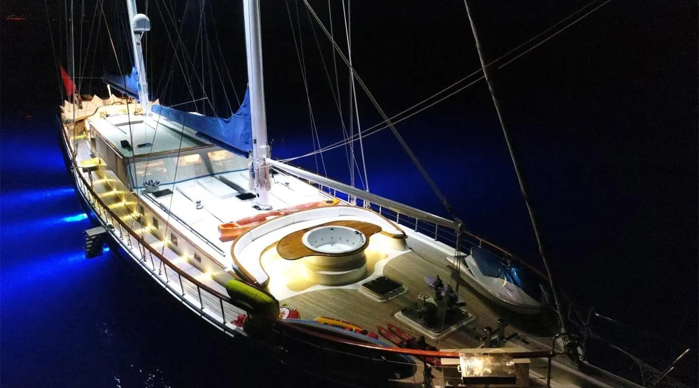 Night view of Ece Berrak sailing yacht with illuminated deck and blue underwater lights