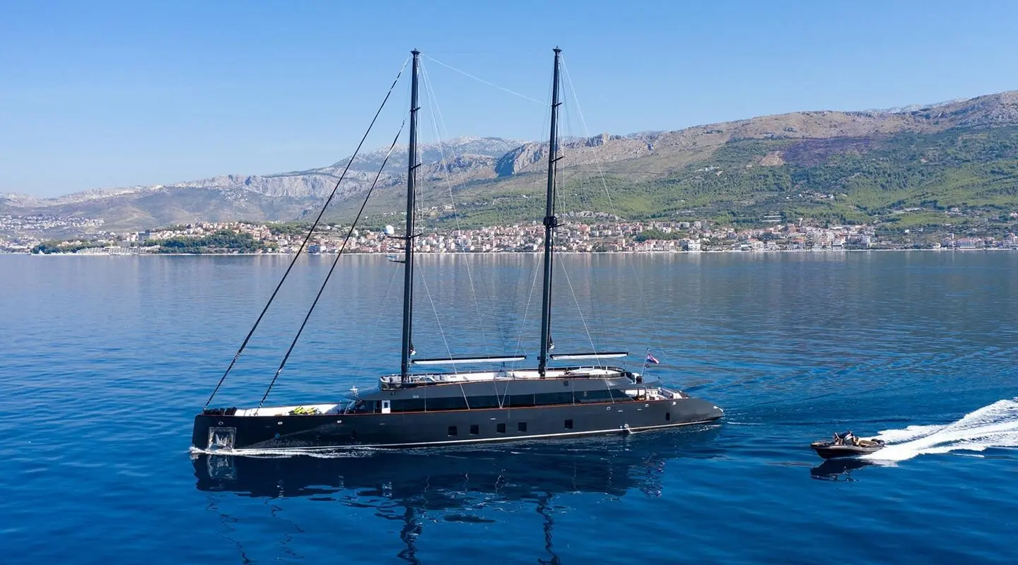 Scorpios motor yacht anchored on calm blue water with clear harbor backdrop