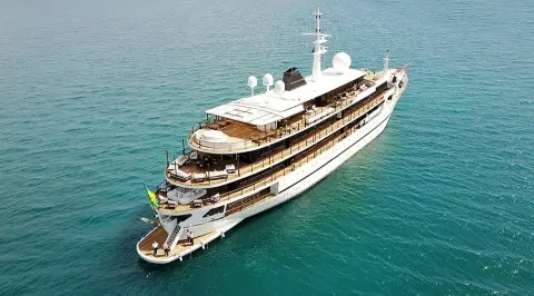 A luxury Chakra yacht anchored in turquoise water, aerial view from above