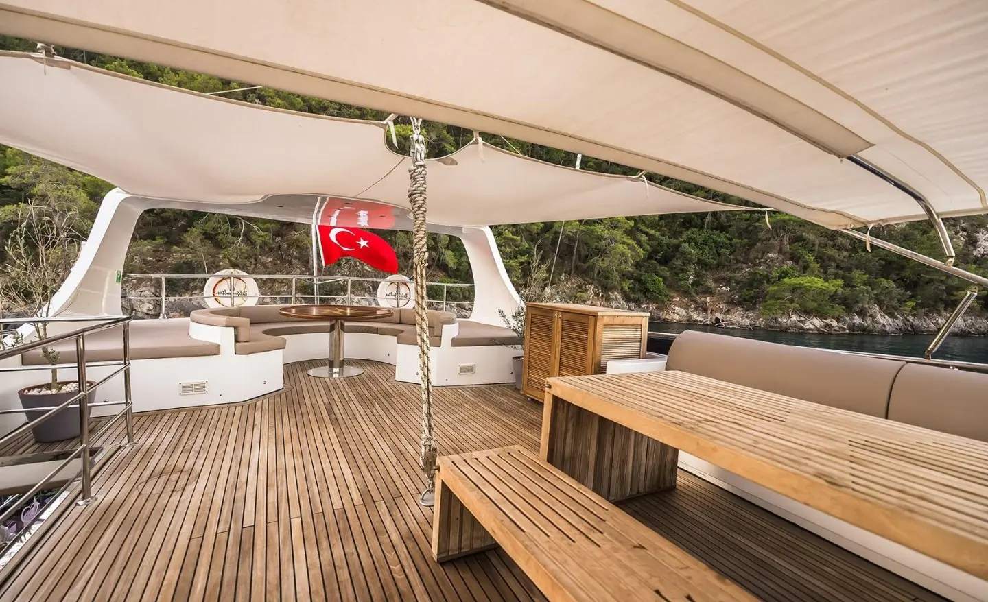 Belgin Sultan luxury gulet deck at sunset with wooden stairs and seating under awning