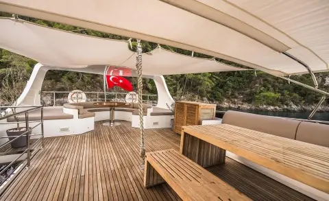 Belgin Sultan luxury gulet deck at sunset with wooden stairs and seating under awning