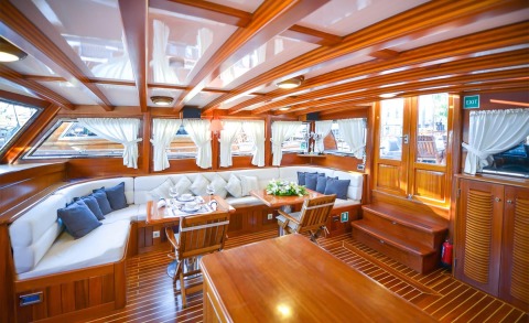 Ros Mare interior lounge with white Cushions and wooden panels on a luxury yacht