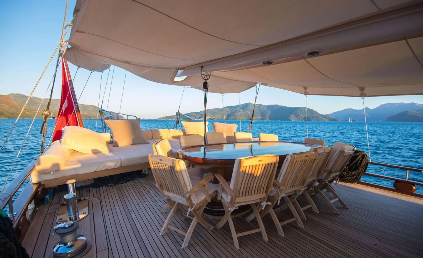 Aft deck of Grande Mare gulet with wooden seating and cushioned benches under a canopy