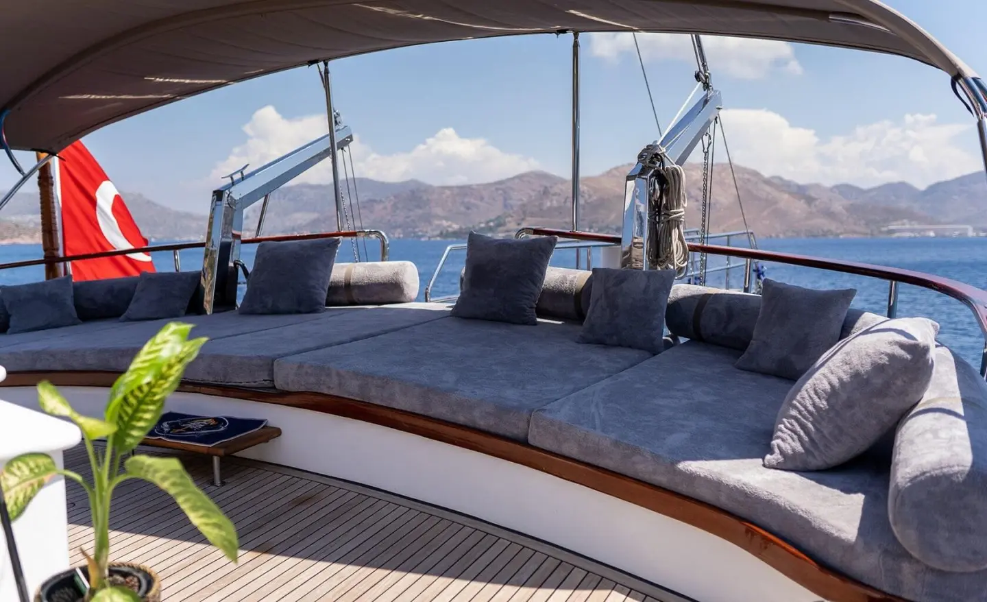 Wide outdoor deck with gray cushions and a sea view on a luxurious yacht